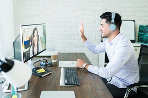 man waving to fellow coworker during virtual meeting