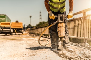 man busting concrete