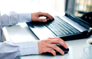 man typing on a laptop