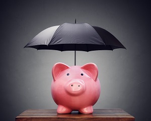 black umbrella over piggy bank